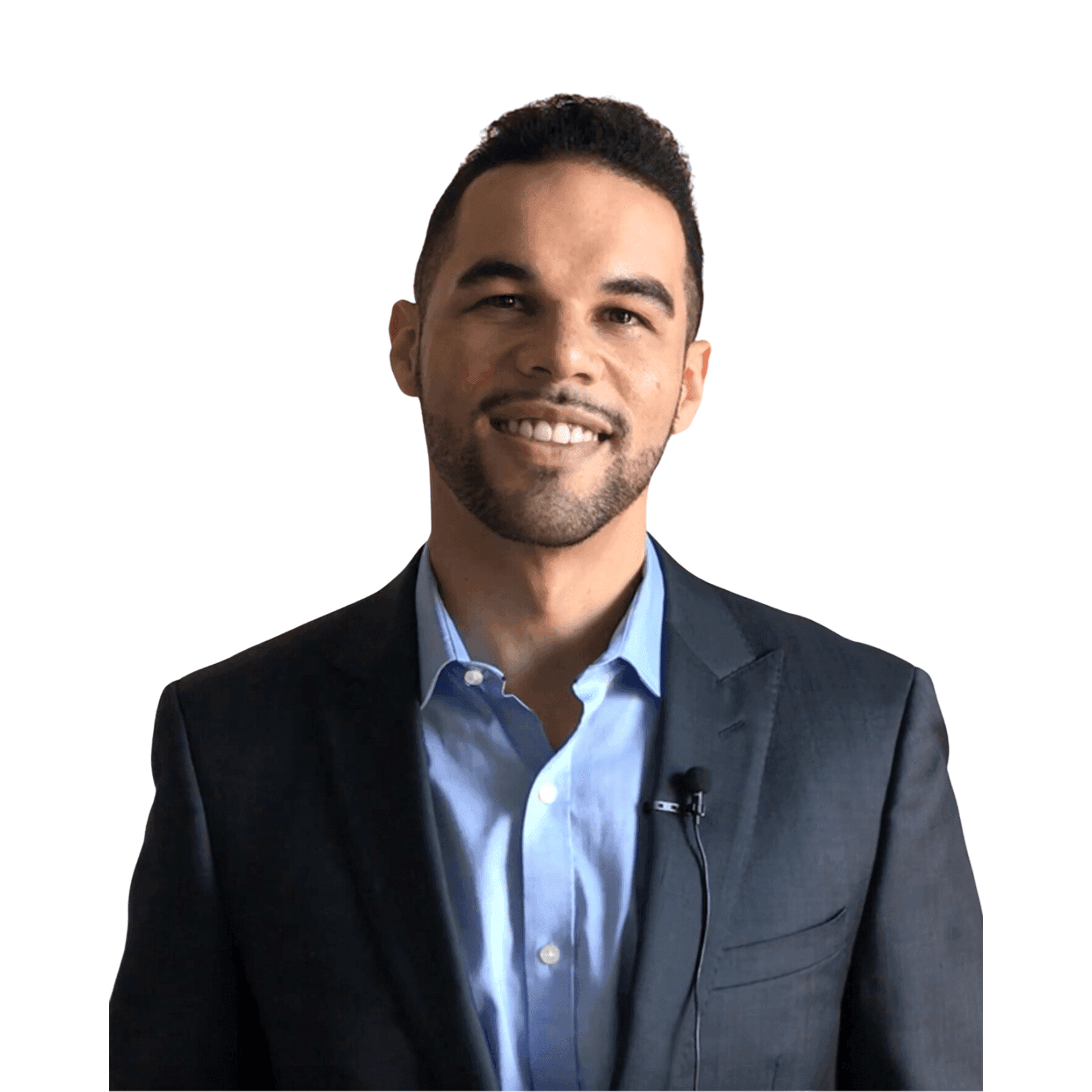 Smiling man in a suit with a lapel microphone, standing against a white background.