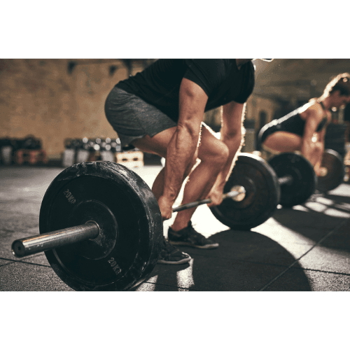 Two individuals performing deadlifts with barbells in a gym setting.