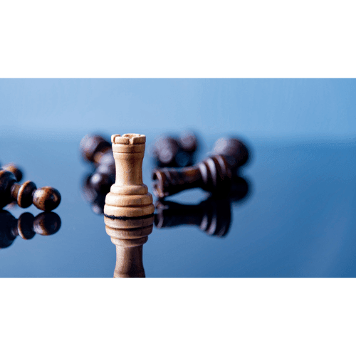 A wooden rook chess piece standing upright on a reflective surface, surrounded by fallen black chess pieces.